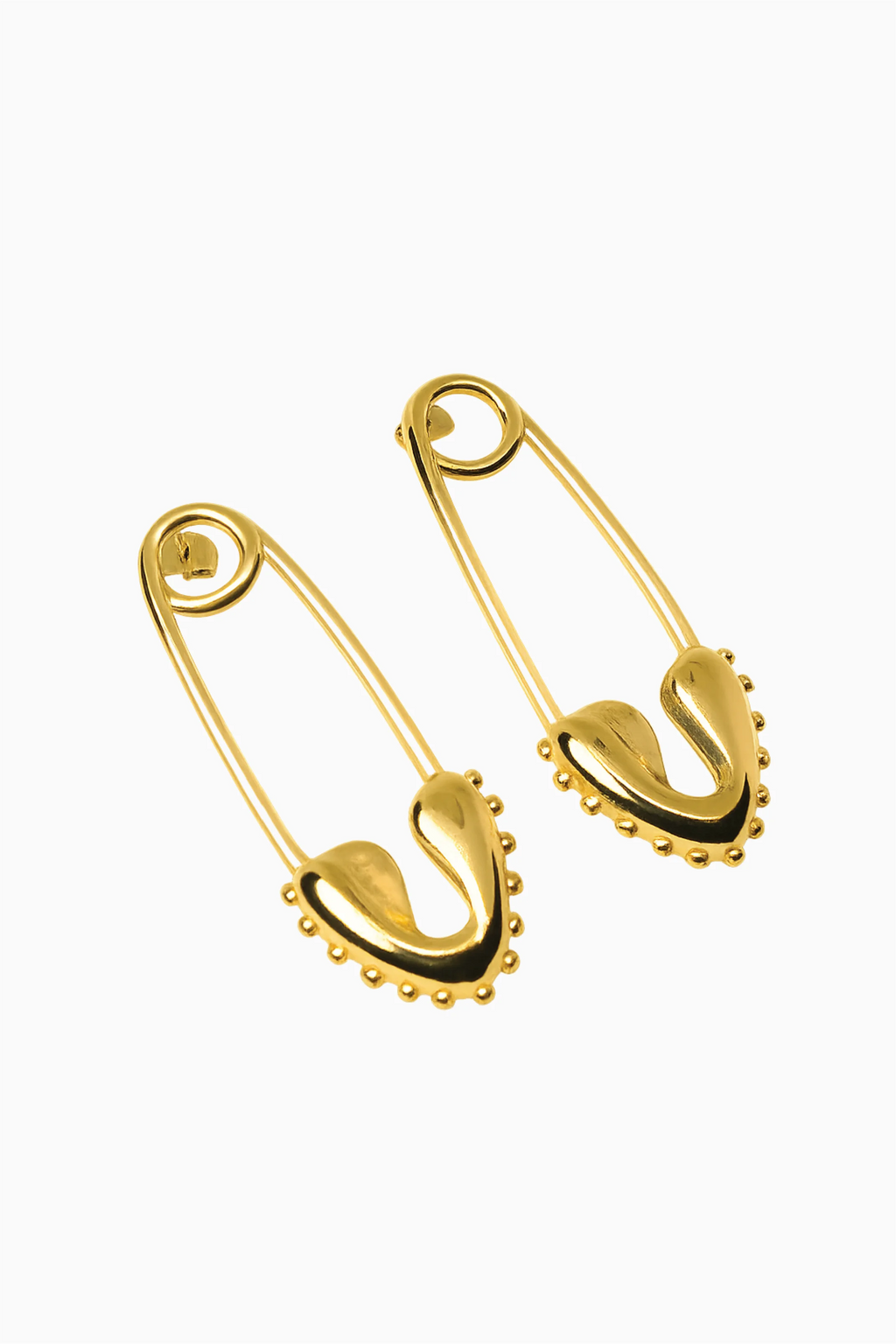 Pair of gold safety pins on a white background