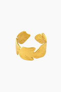 Gold leaf-shaped cuff bracelet on a white background