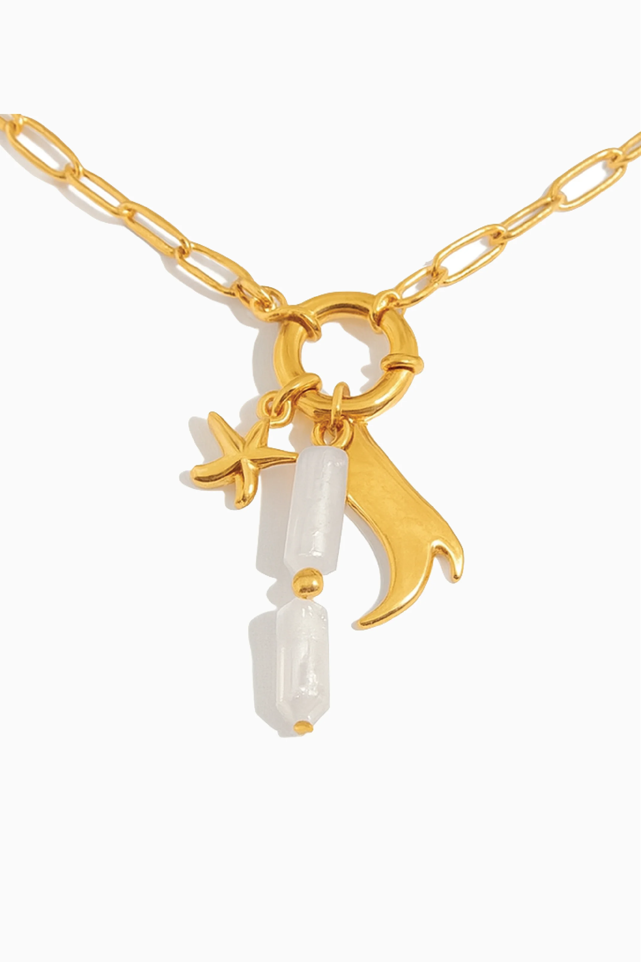 Gold necklace with star and moon charms on a white background