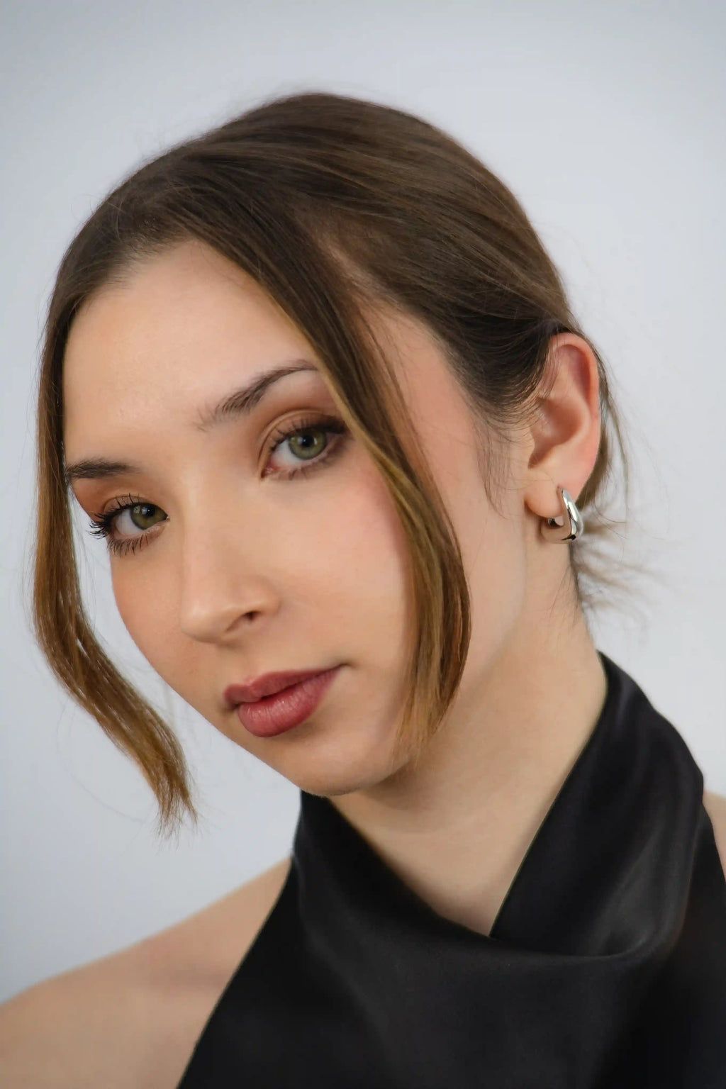 Woman wearing a black high-neck top against a plain background