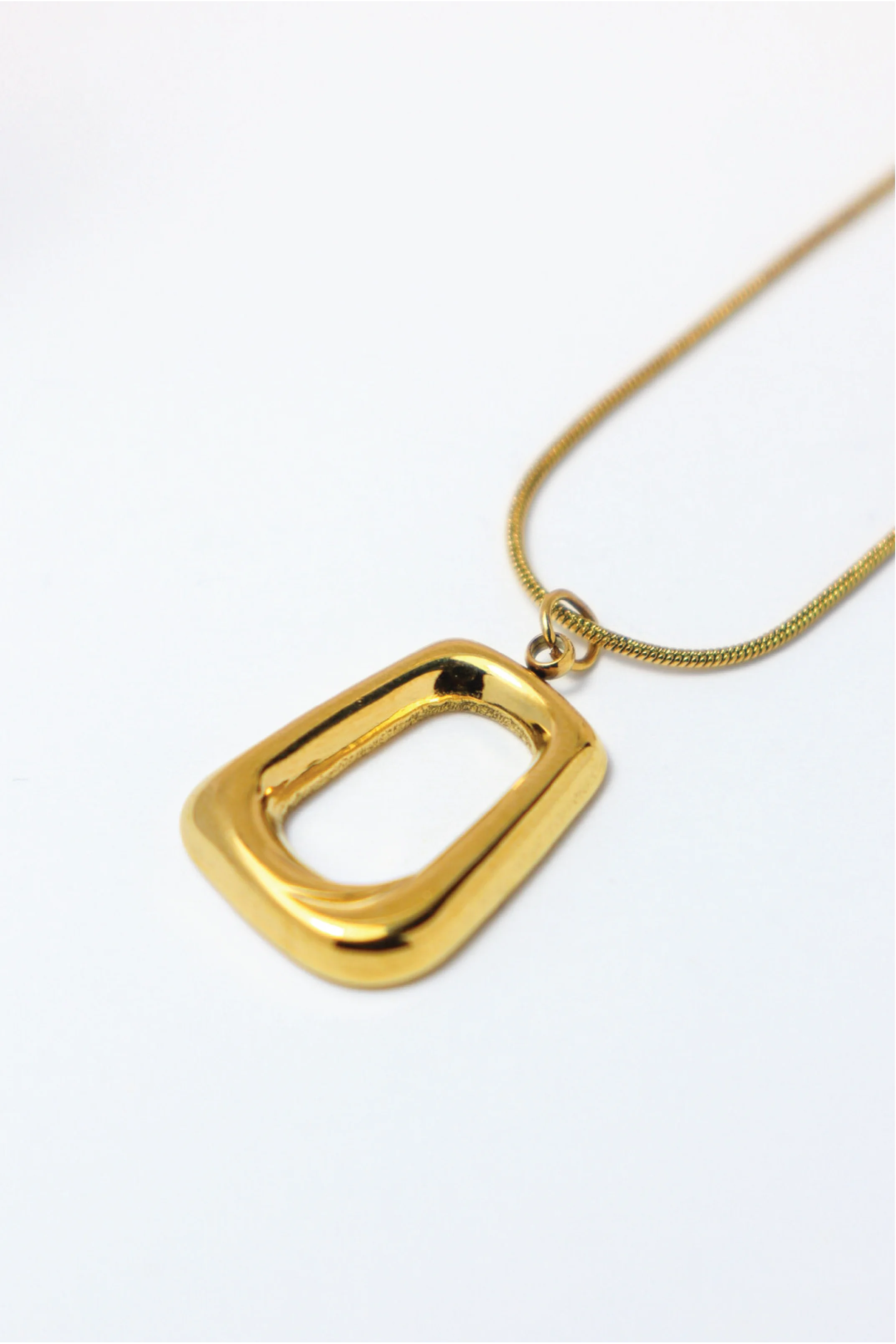 Gold necklace with a rectangular pendant on a white background
